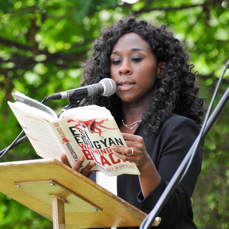 Photo of Esi Edugyan reading from her novel Washington Black at an outdoor podium. 